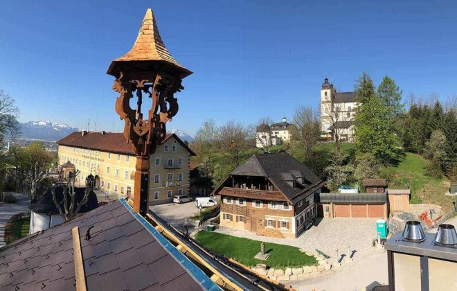 Dachstuhl aus Holz mit Zieraufsatz, traditionelle Zimmerei Salzburg, Holzbauten im Grünen