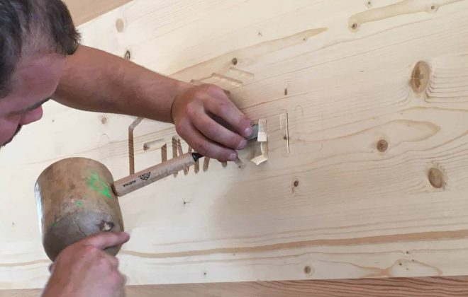Zimmerer arbeitet präzise an Holzverbindung, Holzbau Salzburg, Handwerksqualität Holzbau Gmachl
